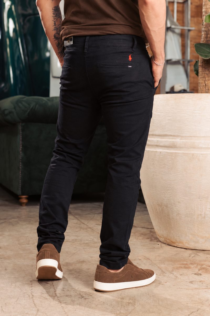 Homem de costas vestindo calça chino preta Ralph Lauren e tênis de camurça marrom